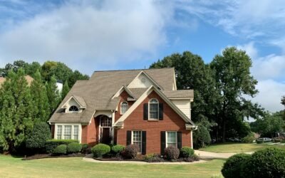 brown and white concrete house near green trees under blue sky during daytime