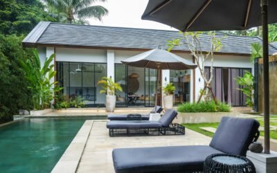 A pool with lounge chairs and an umbrella next to it