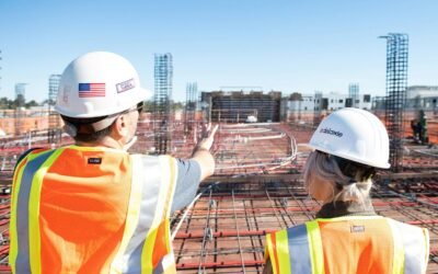 two construction workers in safety vests at site