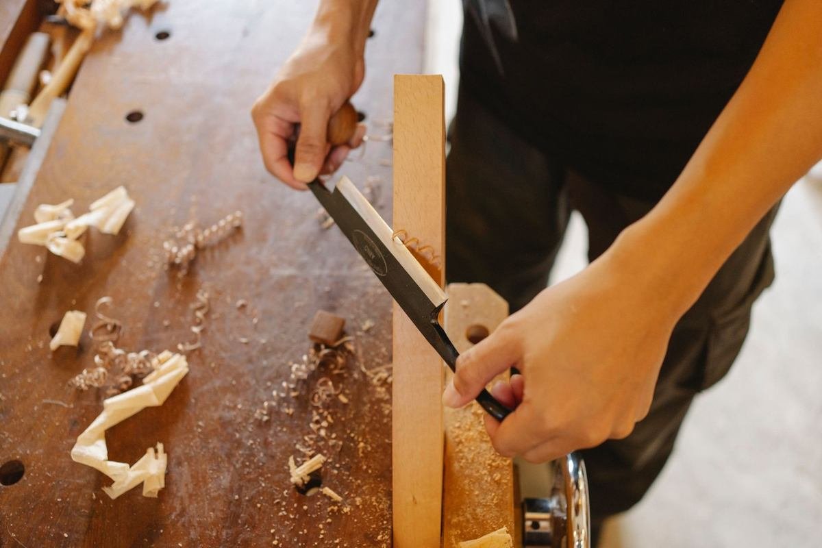 Scie d'une planche sur une table en bois, copeaux et morceaux de bois dispersés Scie d'une planche sur une table en bois, copeaux et morceaux de bois dispersés