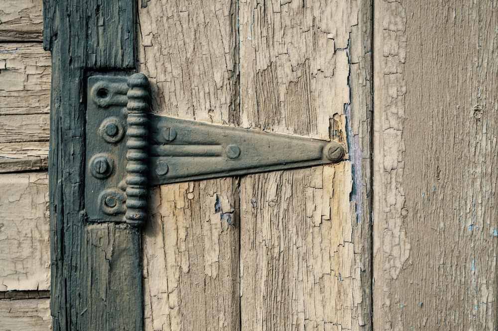 Charnière en fer fixant des planches de bois usées