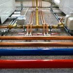 Tuyaux colorés, vannes et manifold sur sol bétonné