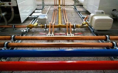 Tuyaux colorés, vannes et manifold sur sol bétonné