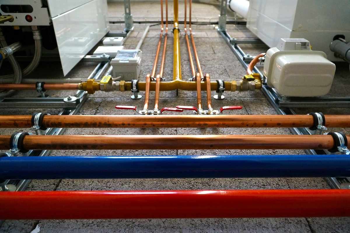Tuyaux colorés, vannes et manifold sur sol bétonné