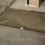 Ciment fraîchement appliqué avec des stries régulières sur le sol