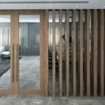 Vue d'une entrée moderne avec portes vitrées et parois en bois