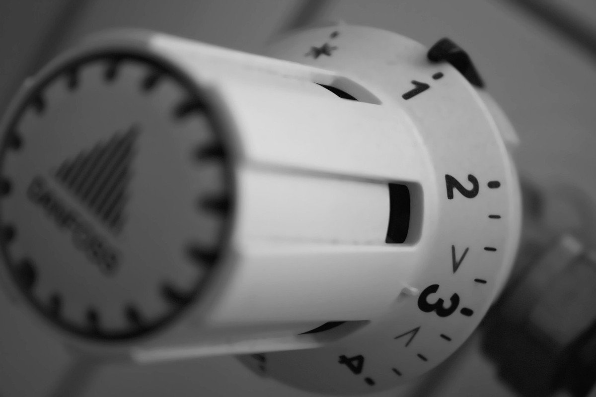 Un thermostat blanc avec cadran numéroté, réglage de température